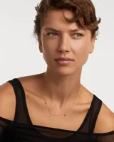 Collar dorado con cadena fina y colgantes de circonitas multicolores en forma de gota.