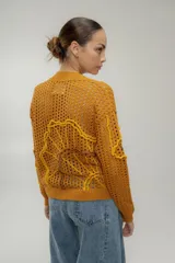 Sweater calado negro con escote en V y bordados dorados con motivos marinos.