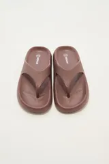 Ojotas marrones con textura en la plantilla y logo de la marca en el lateral.