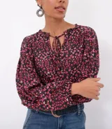 Blusa ancha de viscosa con cuello mao y mangas largas con puños elásticos. Estampado de flores en tonos borgoña y negro.