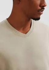 Camiseta básica unisex de color beige, con cuello en V y sin costuras laterales para mayor comodidad.