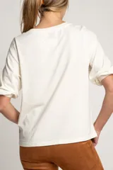 Remera color crema de algodón peinado, corte al cuerpo y mangas globo 3/4.