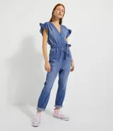 Mono largo de jeans azul claro, con escote en V, mangas cortas con volados, elástico en la cintura, cinturón de ajuste y bolsillos.