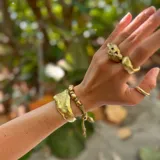 Brazalete rígido plateado con textura irregular.