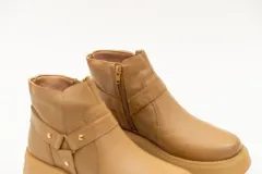 Borcego color beige de cuero con plataforma y aplique de estribo con hebilla.