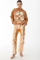 Pantalón cargo metalizado color dorado, con múltiples bolsillos, corte wide leg y tiro medio.