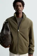 Sobrecamisa verde militar de tejido polar, corte regular fit, cuello alto, manga larga, bolsillos laterales y cierre frontal con cremallera.