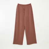 Pantalón ancho color ladrillo, de punto crepé con textura tipo waffle y cintura con cordón ajustable.