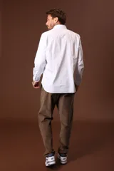 Camisa blanca de manga larga con cuello clásico y cierre frontal con botones.