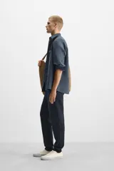 Pantalón negro de corte cropped, con cintura elástica ajustable con cordón, bolsillos laterales y traseros de vivo. El bajo tiene terminación con vuelta.