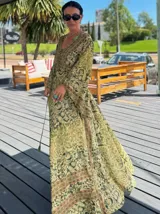 Vestido largo de polysilk con estampado paisley en tonos azul, celeste y dorado. Tiene escote en V, mangas largas acampanadas y corte amplio.