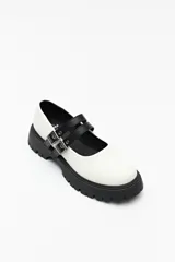 Guillerminas blancas de cuero sintético con suela track negra y doble tira ajustable con hebillas metálicas.