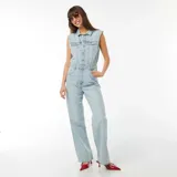 Mono largo de jean celeste, sin mangas, con cuello camisero, cierre frontal con botones, bolsillos delanteros y traseros, y cinturón con hebilla metálica.