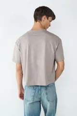 Camiseta color gris topo, estilo boxy, de manga corta y cuello redondo.