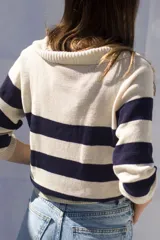 Sweater tejido artesanalmente en hilado 70% algodón y 30% acrílico, con cuello polo y rayas horizontales anchas color azul marino sobre fondo crudo.