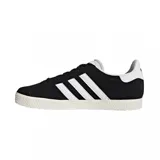 Championes Adidas Gazelle negros con las tres tiras blancas y detalles dorados.