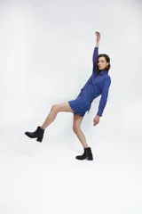 Camisa azul con rayas verticales color naranja, de corte holgado, mangas largas con pinzas laterales y puños anchos. Cuello clásico de gran tamaño.