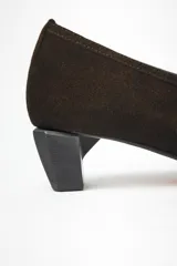 Zapato escotado de cuero gamuzado negro con textura de glitter, con suela de vacuno y taco de madera geométrico.