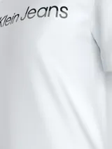 Remera blanca de algodón con cuello redondo y mangas cortas. Estampado frontal con el logo "Calvin Klein Jeans" en color negro.