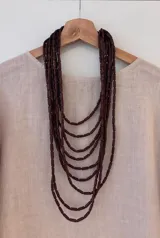 Collar largo de nueve capas con canutillos color borgoña y cierre de botón.