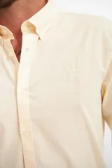 Camisa de hombre color crema, de corte clásico, con cuello abotonado y mangas largas.