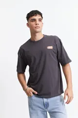 Remera gris oscuro de manga corta con corte boxy, cuello redondo y logo estampado en el pecho.