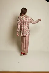 Camisa holgada de terciopelo elastizado con estampado floral y geométrico en tonos borgoña, amarillo y celeste. Corte clásico con cuello solapa y abotonada.