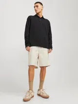 Short chino color beige de lino y algodón, con corte relajado, tiro semi caído, cintura con cordón ajustable, bolsillos delanteros y traseros.