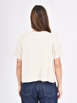 Remera blanca de corte recto con estampado de flores rojas y texto azul "PROFUMO DI FIORI".