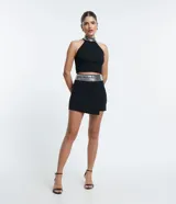 Minifalda negra cruzada de bengalina con cintura ancha de lentejuelas plateadas.