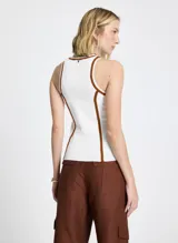 Musculosa blanca de punto con corte recto, cuello redondo, sisas amplias y vivo terracota en cuello y sisas.