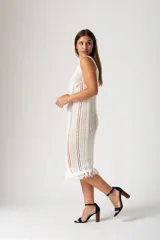 Vestido blanco de algodón con terminaciones de flecos en el ruedo.