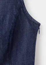 Top crop sin mangas, color azul oscuro, con cuello redondo y tirantes anchos. Presenta un efecto denim y cierre de botón en la parte trasera del cuello.