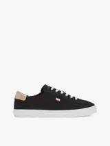 Zapatillas Tommy Hilfiger de lona negra con suela blanca de goma y talón dorado metalizado.