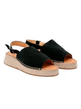 Sandalias negras de cuero con plataforma de yute y tira trasera con hebilla. Diseño basado en tendencias españolas.