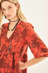 Vestido midi color ladrillo con estampado floral marrón, escote en V, mangas 3/4 abullonadas y cinturón con aplique de flor.