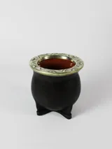 Mate de cer	ámica negro con base de tres patas y boca cincelada con detalles plateados. Interior color marr	ón.