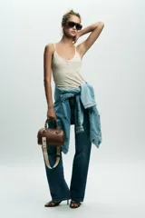 Bolso marrón formato city con asa doble de mano con detalles metálicos y correa interior extraíble en tejido canvas con posición bandolera. Bolsillo interior con cierre mediante cremallera metálica.