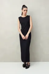 Vestido largo negro de punto con textura acanalada, corte recto y aberturas laterales.
