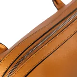 Cartera tipo tote de cuero sintético color habano, con doble asa corta y correa larga regulable extraíble. Tiene cierre superior, un bolsillo interno con cierre y otro abierto.