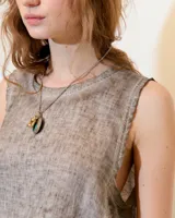Musculosa gris de lino con cuello a la base y recortes laterales en lino de punto. Tiene un lavado fade teñido en frío que genera un efecto melange.