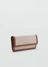 Billetera rectangular grande color beige con efecto rafia y ribetes marrones en contraste. Tiene cierre de solapa con botón a presión, bolsillo interior con cremallera y logo en relieve.