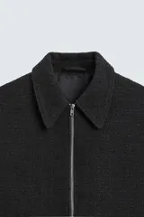 Sobrecamisa de hombre regular fit confeccionada en tejido con estructura irregular en tonos beige, marrón y negro. Tiene cuello solapa, manga larga con puños abotonados, bolsillos laterales y cierre frontal con cremallera.