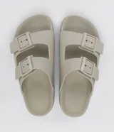 Ojota slide de PVC color gris claro, con dos tiras ajustables y hebillas.