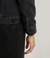 Campera de jean para mujer marca Blue Steel, color negro con lavado sutil. Cuenta con forro de felpa negro en el cuello y el interior, cuello camisero, manga larga, bolsillos delanteros con solapa y cierre frontal mediante botones metálicos.