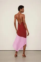 Vestido midi de seda color ladrillo y falda inferior color rosa, con breteles finos, escote en V y abertura lateral en la falda.