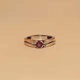 Anillo de plata y oro con circonia roja central.