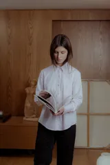 Camisa de vestir rosa claro a rayas verticales blancas, de corte clásico y mangas largas.