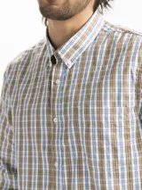 Camisa celeste y blanca a rayas verticales, de manga larga y corte clásico. Tiene cuello abotonado y bolsillo en el pecho.