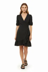 Vestido corto negro con escote en V, mangas cortas abullonadas, corte cruzado con volantes y lazo lateral.